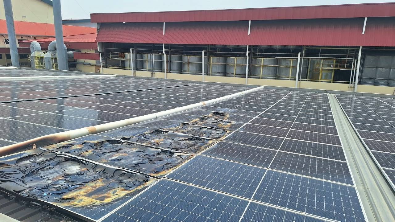 A rooftop solar array after a fire: a row of modules burnt down to the backsheet, with undamaged panels immediately on either side of them